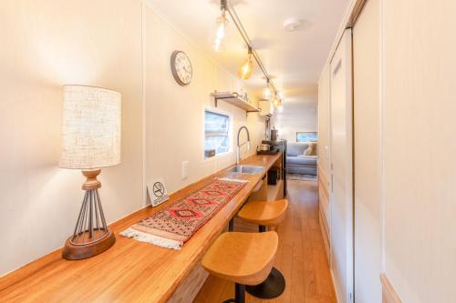 a living room with a table and a lamp at 本栖ベース～ヴィンテージトレーラーとバレルサウナ’1日1組限定’の貸切別荘～ in Fujikawaguchiko