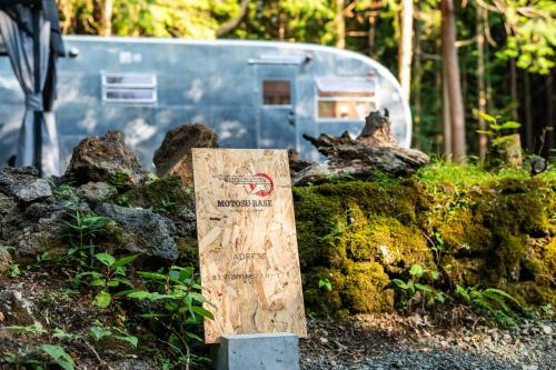 a sign sitting next to a pile of moss at 本栖ベース～ヴィンテージトレーラーとバレルサウナ’1日1組限定’の貸切別荘～ in Fujikawaguchiko