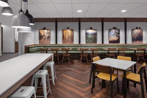 Fairfield by Marriott Inn & Suites Hailey Sun Valley في هايلي: مطعم به طاولات وكراسي وبار