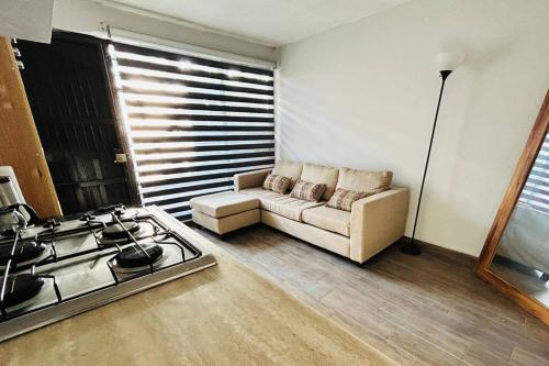 un soggiorno con divano e piano cottura di Cómodo y sencillo estudio bien ubicado a Guadalajara