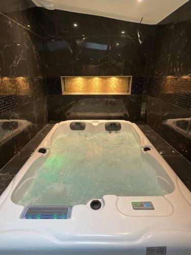 a bath tub with green water in a bathroom at La Golden Suite in Cambrai
