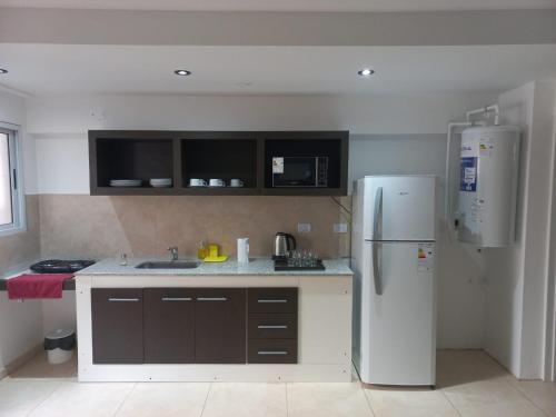 a kitchen with a white refrigerator and a sink at Grace Apartaments in San Juan