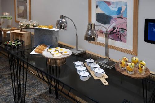 a table with cups and plates of food on it at Delta Hotels by Marriott Edinburgh in Edinburgh
