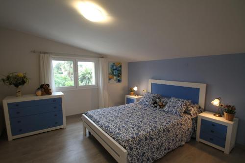 a bedroom with a blue bed and two night stands at ARENDA Villa Amelie en Pino Alto in Miami Platja