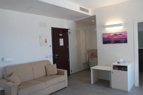 a living room with a couch and a bathroom at Hotel Miramare in Marina di Ragusa
