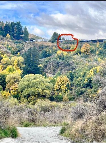 a red spot on top of a hill with trees at Garden Of Eden in Queenstown
