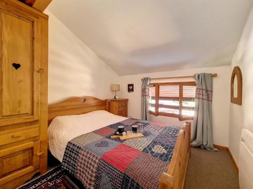 een slaapkamer met een bed met een quilt bij Appartement Saint-Martin-de-Belleville, 2 pièces, 4 personnes - FR-1-344-860 in Saint-Martin-de-Belleville