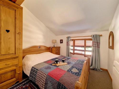 a bedroom with a bed with a quilt on it at Appartement moderne mansardé Au pied des pistes Centre village - FR-1-344-860 in Saint-Martin-de-Belleville