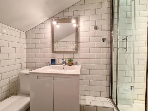 uma casa de banho branca com um lavatório e um espelho em Appartement Saint-Martin-de-Belleville, 2 pièces, 4 personnes - FR-1-344-860 em Saint-Martin-de-Belleville
