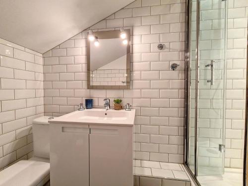 a white bathroom with a sink and a mirror at Appartement moderne mansardé Au pied des pistes Centre village - FR-1-344-860 in Saint-Martin-de-Belleville