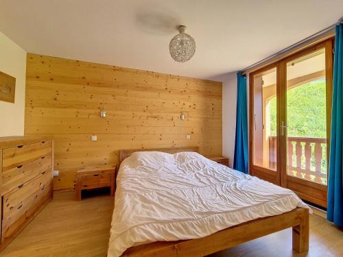 a bedroom with a bed and a wooden wall at Appartement en duplex, 3 pièces, au pied des pistes, balcon, casier à ski, classé 3 flocons or - FR-1-344-908 in Saint-Martin-de-Belleville