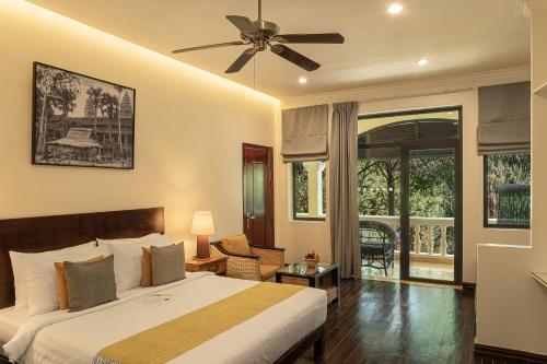 a hotel room with a bed and a balcony at Pavillon d'Orient Boutique Hotel in Siem Reap