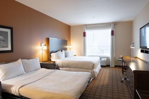 a hotel room with two beds and a large window at Four Points by Sheraton Edmonton International Airport in Nisku