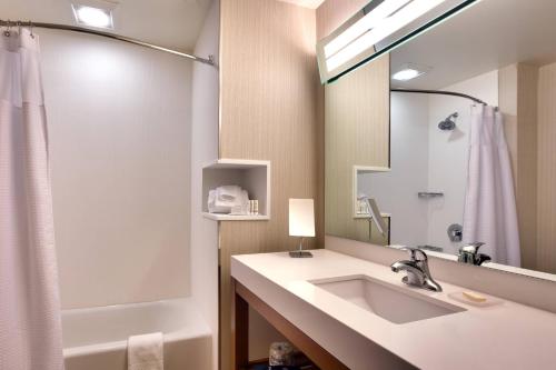 a bathroom with a sink and a mirror at Courtyard by Marriott Oahu North Shore in Laie