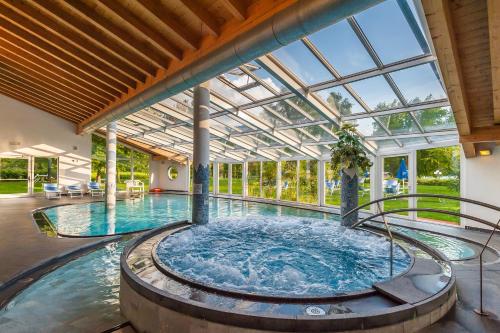 a large swimming pool in a large building at Hotel Al Sorriso Greenpark & Wellness in Levico Terme