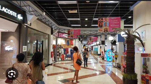 a group of people walking through a shopping mall at Appartement Clos du bois in Fort-de-France