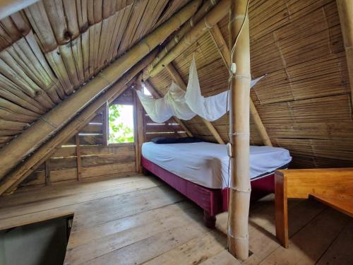 a bedroom with a bed in a wooden house at Kamala Surf & Backpacker Hostel in Montañita