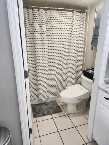 a bathroom with a toilet and a shower curtain at Modern Beach Condo-Daytona Beach in Daytona Beach
