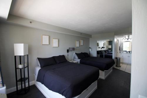 ein Schlafzimmer mit 2 Betten und ein Wohnzimmer in der Unterkunft Modern Beach Condo-Daytona Beach in Daytona Beach