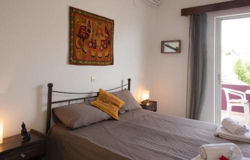 Un dormitorio con una cama con almohadas amarillas y una ventana en Aumkara, en Skala Eresou