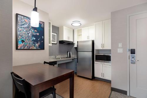 a kitchen with a table and a stainless steel refrigerator at Residence Inn by Marriott Boston Back Bay/Fenway in Boston
