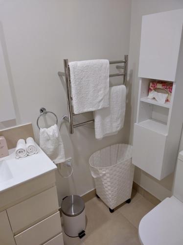 ein Bad mit einem Waschbecken, einem WC und Handtüchern in der Unterkunft Macleay Island Getaway in Macleay Island