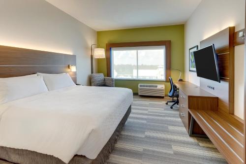 a hotel room with a bed and a flat screen tv at Holiday Inn Express - Wilmington - Porters Neck by IHG in Wilmington