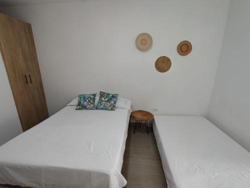 2 Betten in einem Zimmer mit weißen Wänden in der Unterkunft Lagom Apartamentos San Rafael in San Rafael