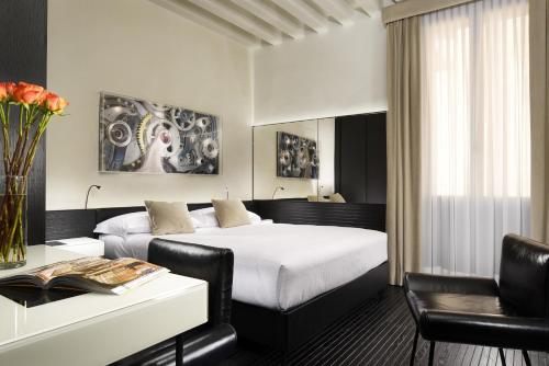 a hotel room with a large bed and a large window at Hotel L'Orologio - WTB Hotels in Venice