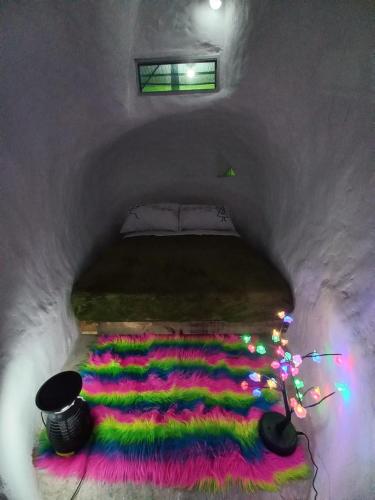 a room with a bed with colored lights in it at La Bota del Gigante in Gigante