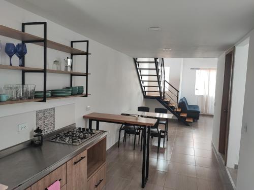 eine Küche und ein Esszimmer mit einem Tisch und einer Treppe in der Unterkunft Lagom Apartamentos San Rafael in San Rafael