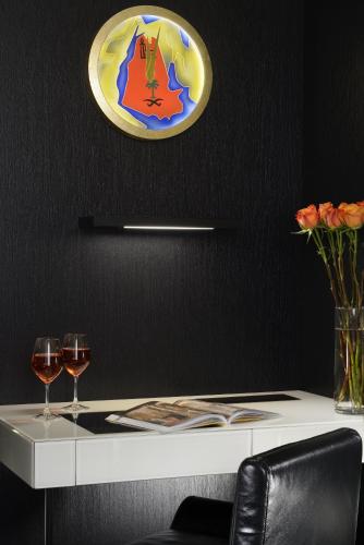 a table with two wine glasses and a plate on the wall at Hotel L'Orologio Venezia - WTB Hotels in Venice
