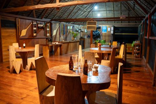 a restaurant with wooden tables and chairs with bottles at Ecolucerna Lodge Tambopata in Puerto Maldonado