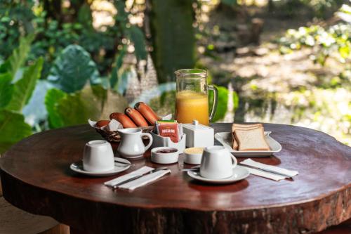 a table with a plate of food and a glass of orange juice at Ecolucerna Lodge Tambopata in Puerto Maldonado
