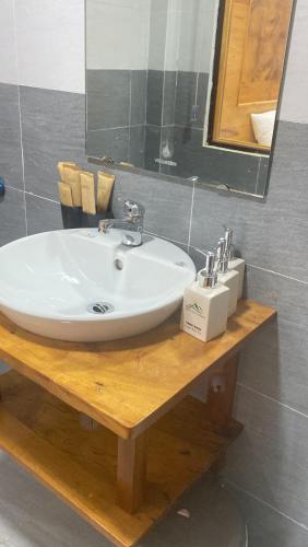 a bathroom with a white sink and a mirror at Sun Hill's House in Cham Ta Lao