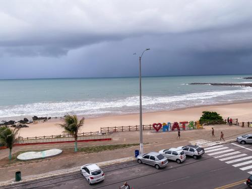 un gruppo di auto parcheggiate vicino alla spiaggia di Acomodação aconchegante à beira- mar a Natal