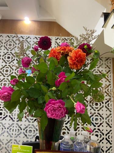 a vase filled with colorful flowers on a table at ROSE MOTEL in Sa Pa
