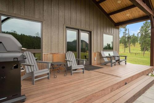 a screened in porch with two chairs and a table at Hot Shot Hideaway in Custer