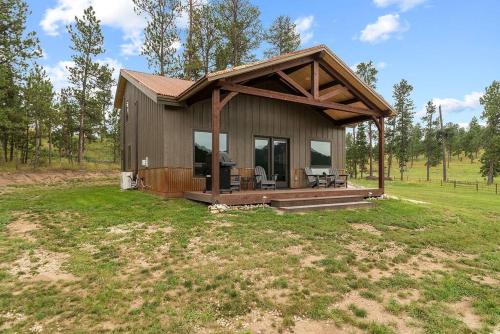 a small house with a porch in a field at Hot Shot Hideaway in Custer