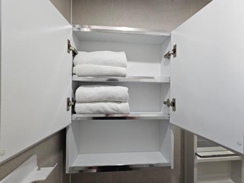 Un armario blanco con toallas blancas. en Maison Apartment Residense, en Seúl
