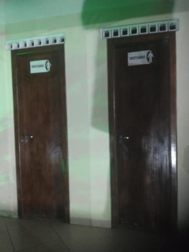 two wooden doors with signs on them on a wall at Aeroporto in Salvador