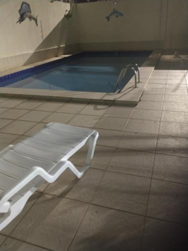 a white bench next to a swimming pool at Aeroporto in Salvador