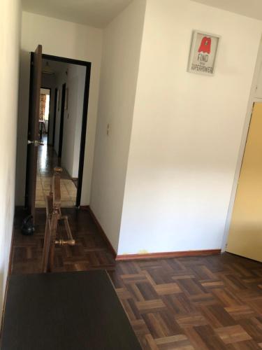 um corredor com uma parede branca e um piso de madeira em Ordeig 2223 em Montevidéu