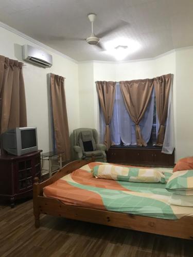 - une chambre avec un lit, une télévision et une fenêtre dans l'établissement Samba Guest House, Kota Bharu, Kelantan, à Kota Bharu