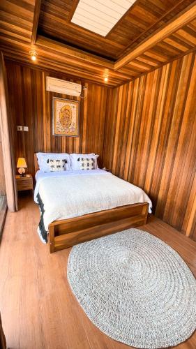 a bedroom with a bed and a rug at The Toya Bali - Private Room & Jacuzzi in Bangli