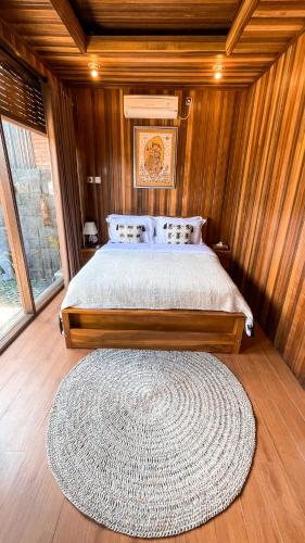 een slaapkamer met een bed en een groot tapijt bij The Toya Bali - Private Room & Jacuzzi in Bangli