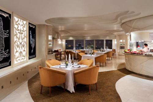 um restaurante com mesas e cadeiras e um bar em JW Marriott Shanghai at Tomorrow Square em Xangai