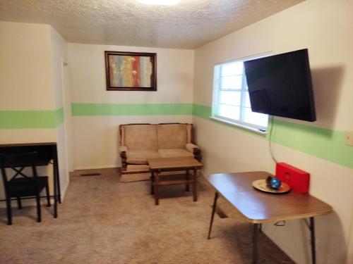 a living room with a television and a chair and a table at Golden Sunflower's Apt E in Lawton