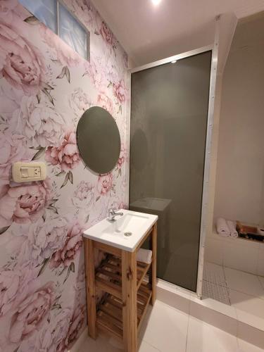 a bathroom with a sink and a pink flower wallpaper at Departamentos Ines 1 in Junín