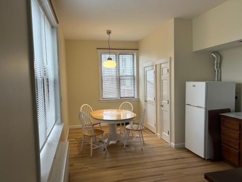 a kitchen and dining room with a table and a refrigerator at Lord Medford Apartments in Medford